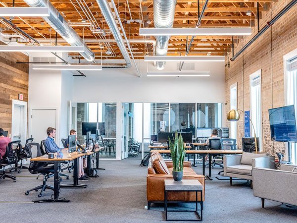 A group of professionals sitting at desks in an office, focused on their work and using computers.
